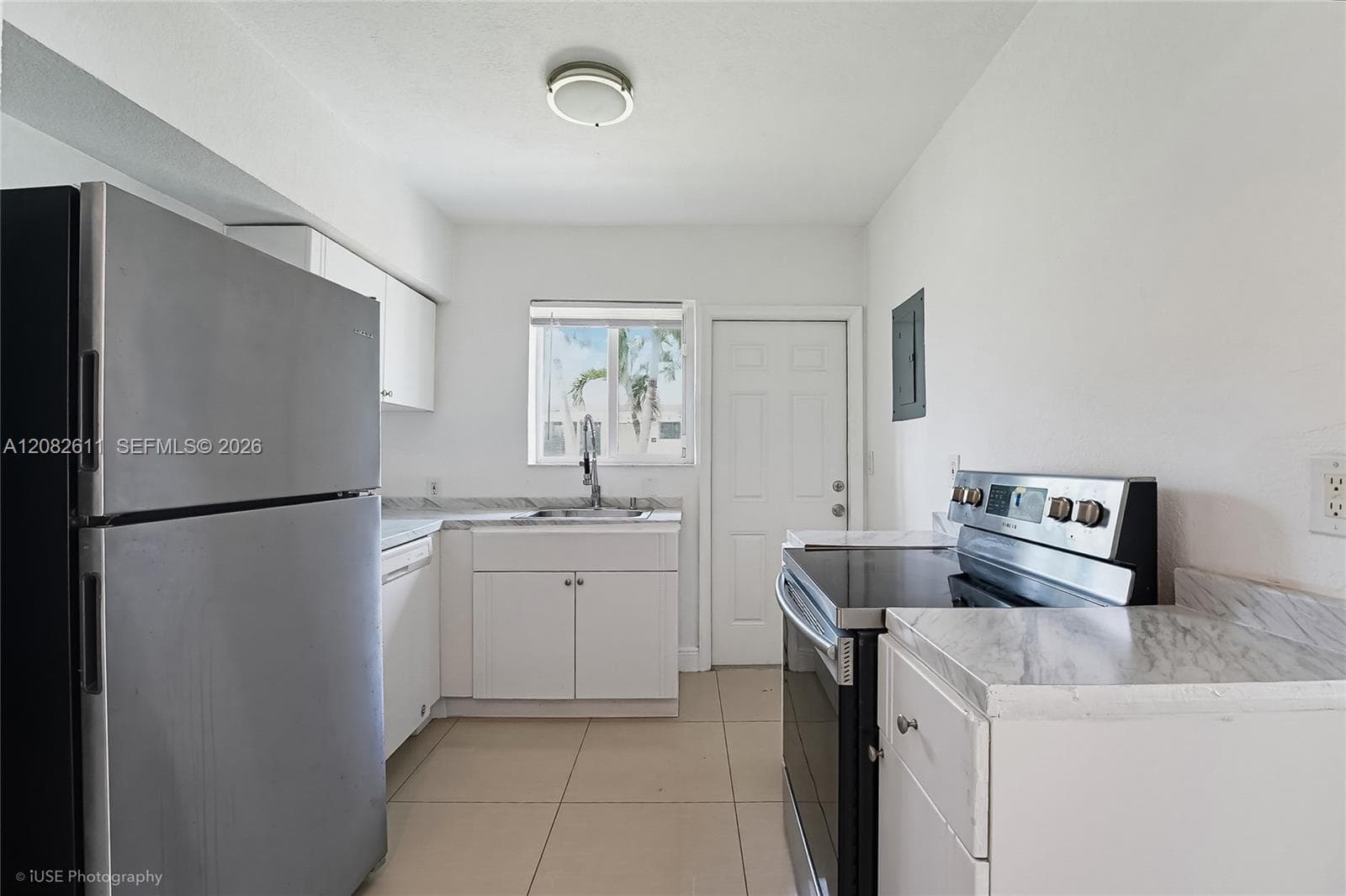 Kitchen featuring white cabinetry, stone-finish countertops, stainless steel refrigerator, electric range, and tile flooring