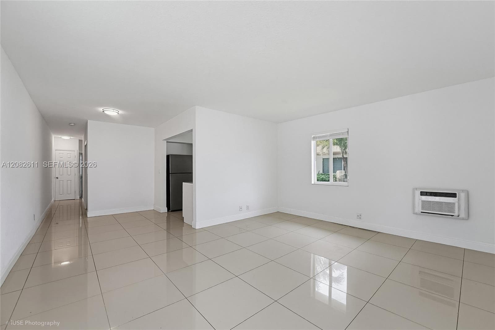 Polished tile flooring, neutral wall finishes, and a wall-mounted air conditioning unit