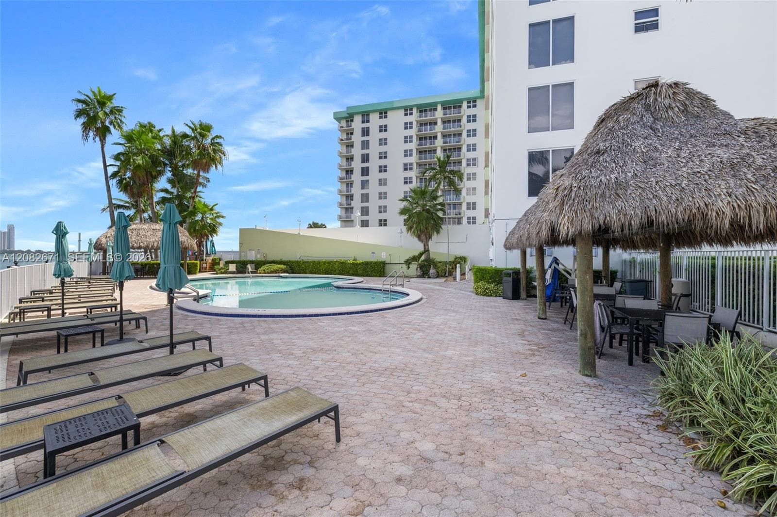 Heated bayfront pool with tiki hut and lounge deck.