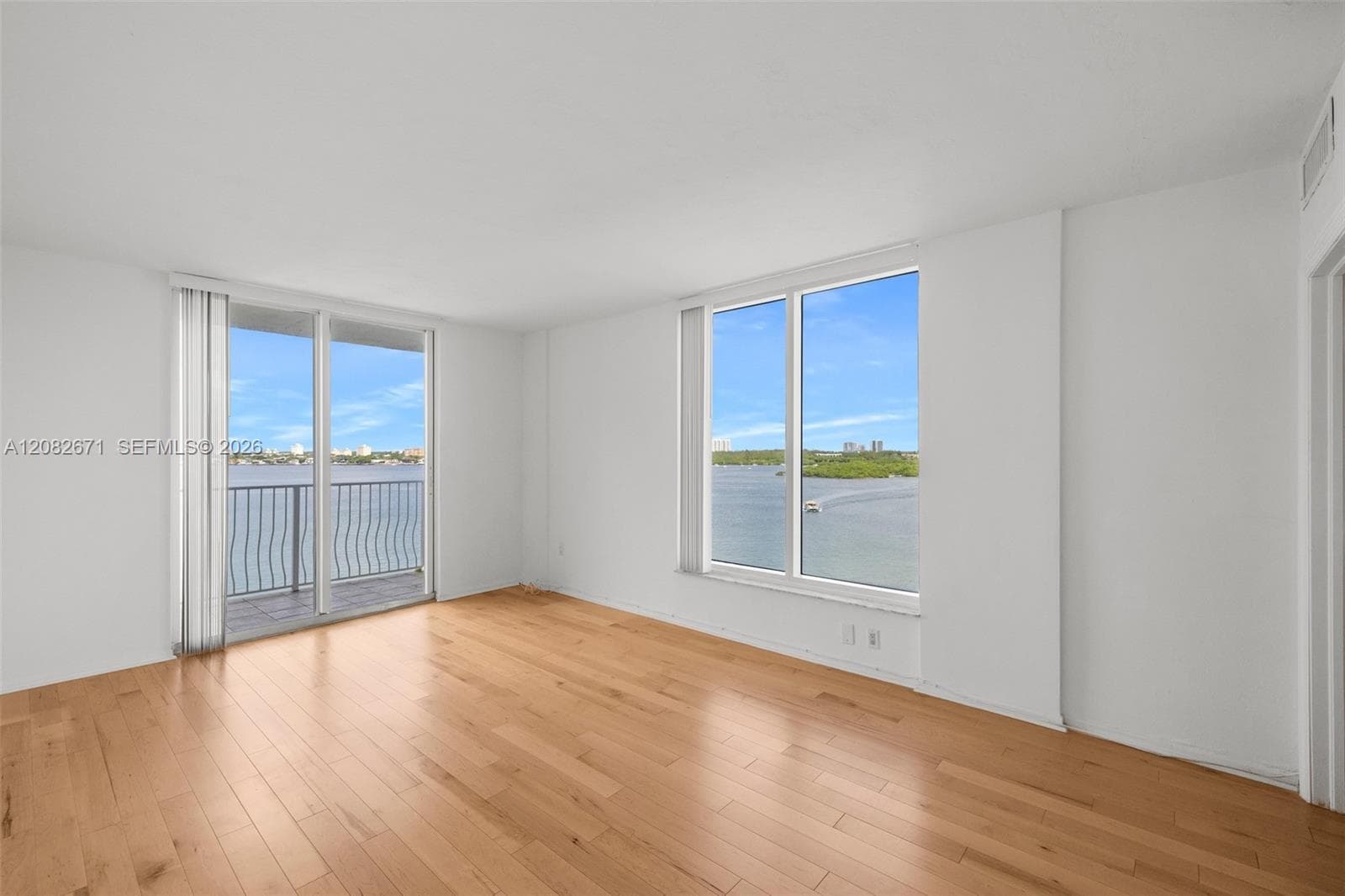 Primary suite in its current state, showing the water-view window wall.