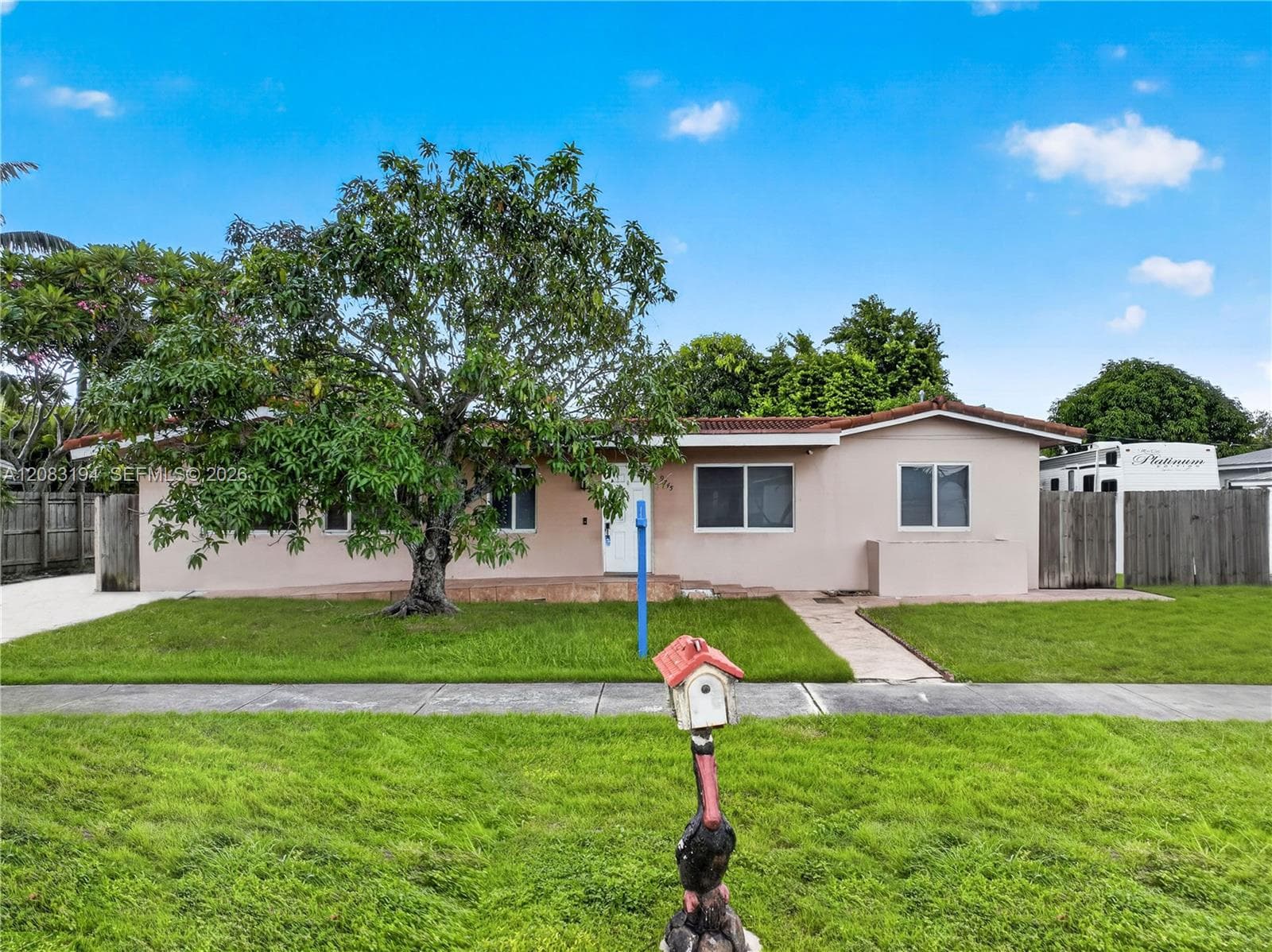 Single-story exterior featuring a concrete-tile roof, stucco siding, and a covered entryway