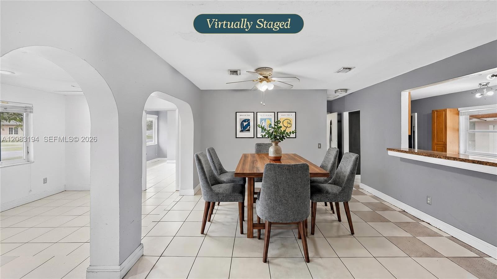 Open interior featuring arched doorways, ceramic tile flooring, and a stone-topped breakfast bar