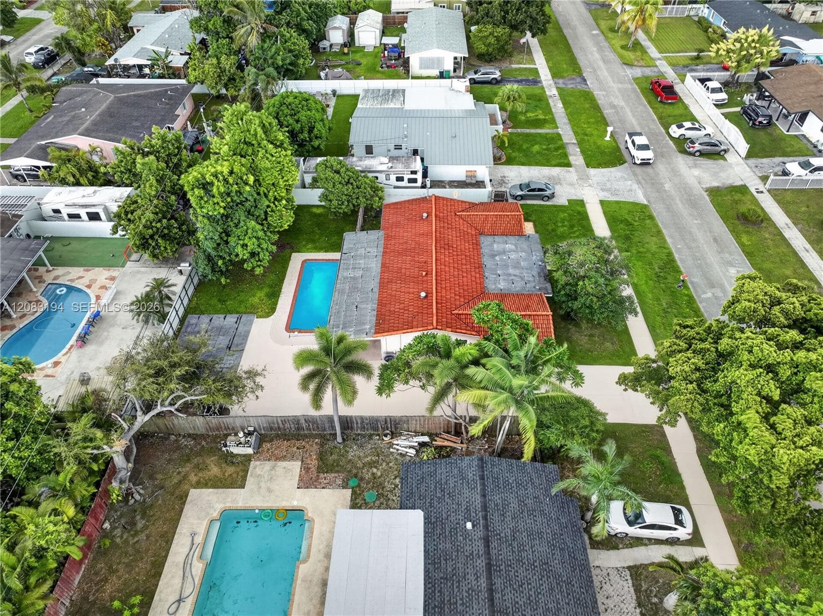 Aerial perspective featuring a terracotta-tiled roof and an inground rectangular swimming pool with a concrete pool deck
