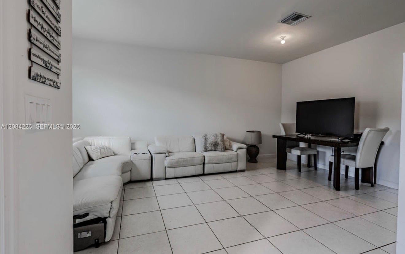 Neutral-toned ceramic tile flooring throughout, clean white wall finishes, and flush-mount lighting fixtures