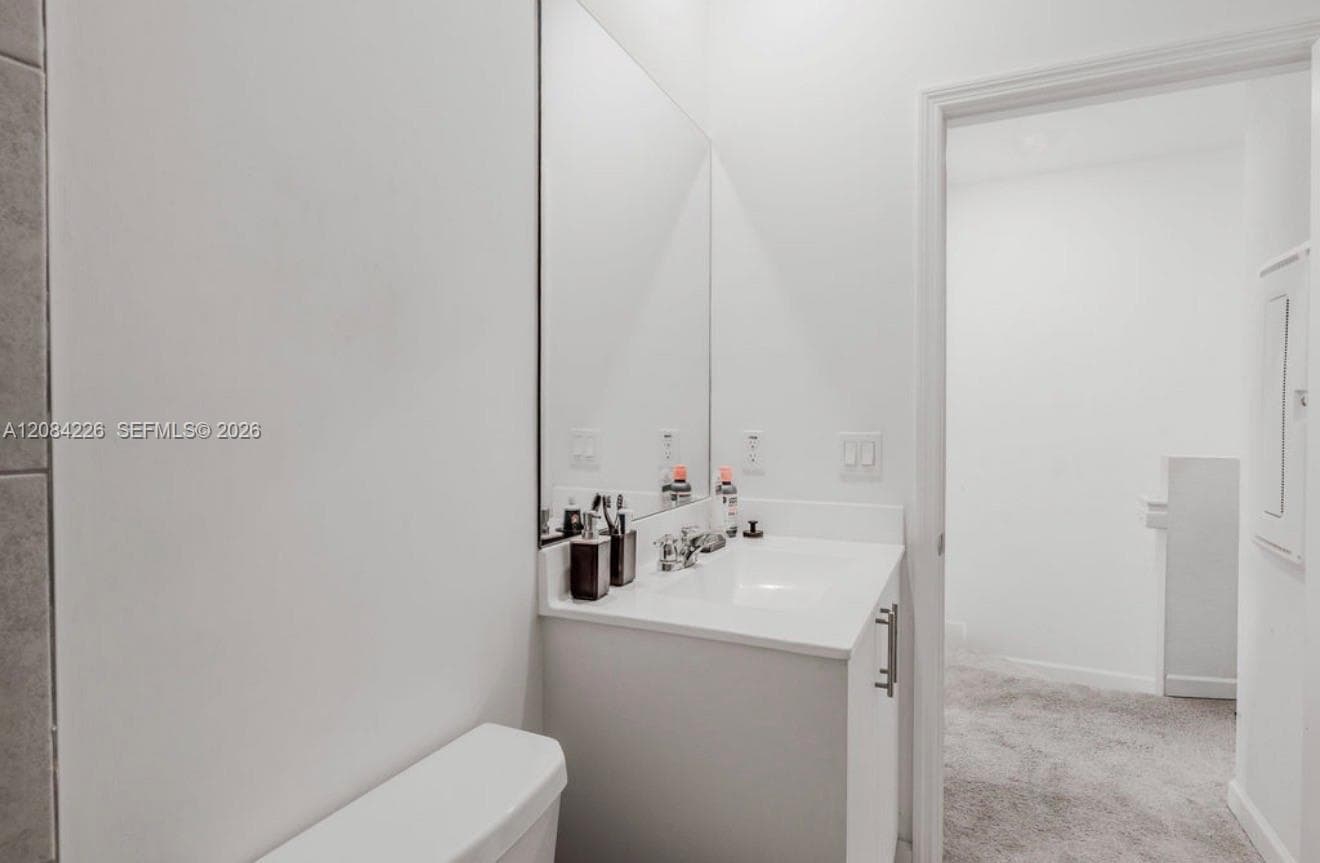 Vanity featuring a solid-surface countertop with an integrated basin and polished chrome faucet, paired with a full-height wall-mounted mirror
