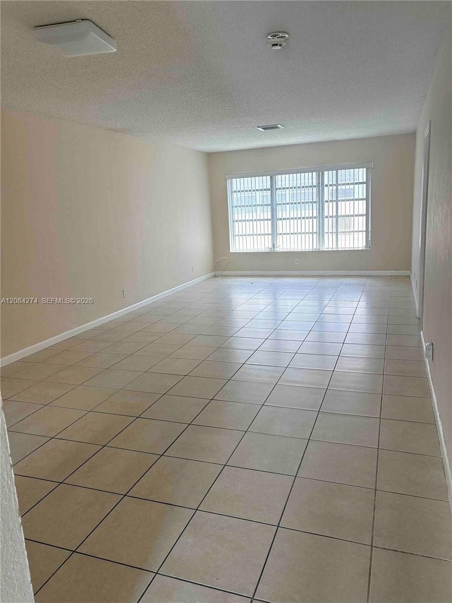 Tile flooring, multiple windows with horizontal blinds, flush mount ceiling lighting