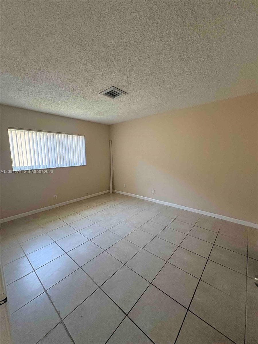 Square tile flooring, neutral wall tones, and horizontal window blinds