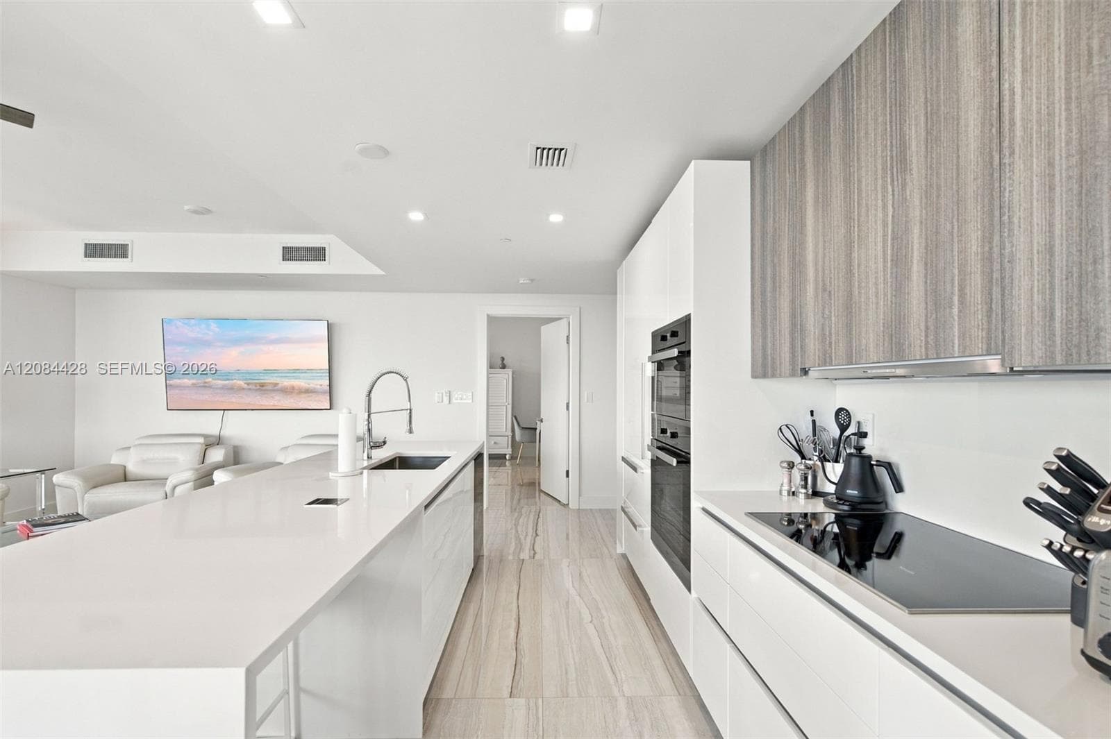 Sleek kitchen with extensive cabinetry, built-in appliances and separate cooktop.