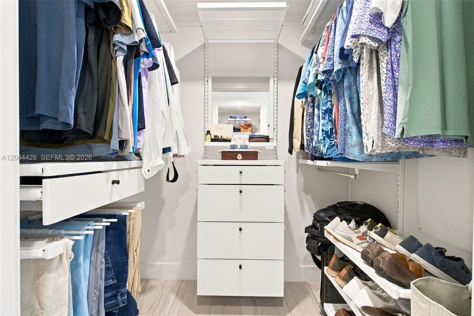 First of two separate custom-fitted walk-in closets with built-in drawers and hanging storage. Closets will be cleared for tenant use.