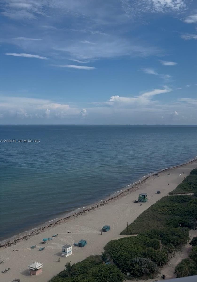 Direct oceanfront exposure featuring an expansive sandy shoreline and coastal vegetation