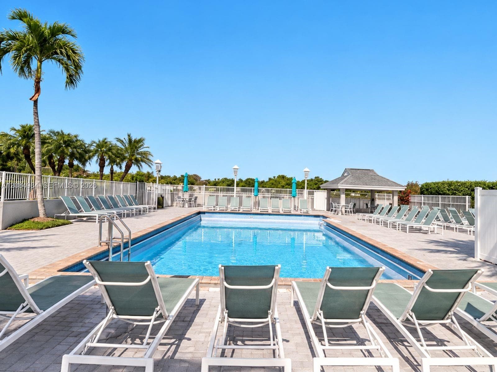 Resort-style community swimming pool with lounge chairs and spacious sun deck.