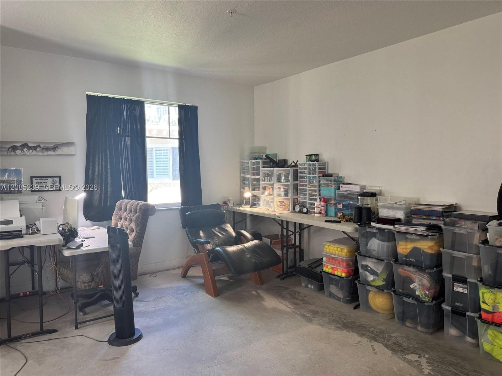 Room with neutral walls, concrete flooring, and a single-pane window