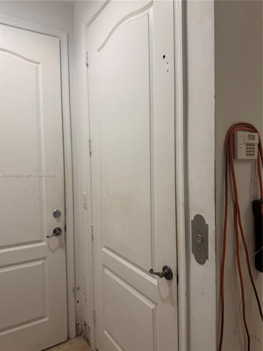 Two-panel arch-top interior doors featuring satin nickel hardware and wall-mounted security system control panel