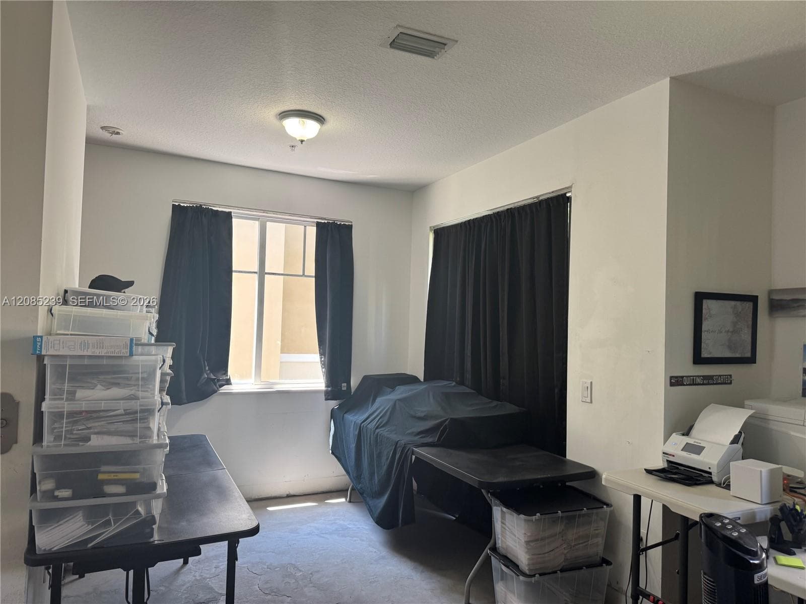 Room featuring neutral walls, ceiling-mounted light fixture, and multiple windows