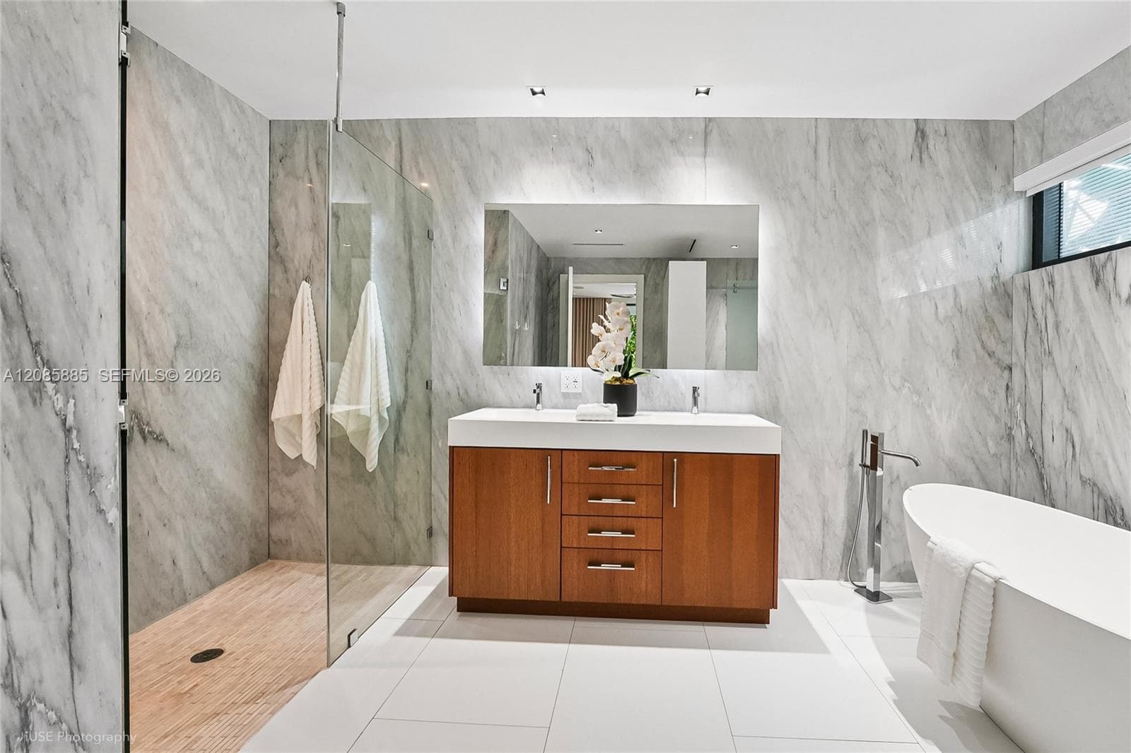 A spa-inspired retreat featuring an oval soaking tub, a separate glass-enclosed shower, and a double vanity — designed for a truly luxurious bathing experience