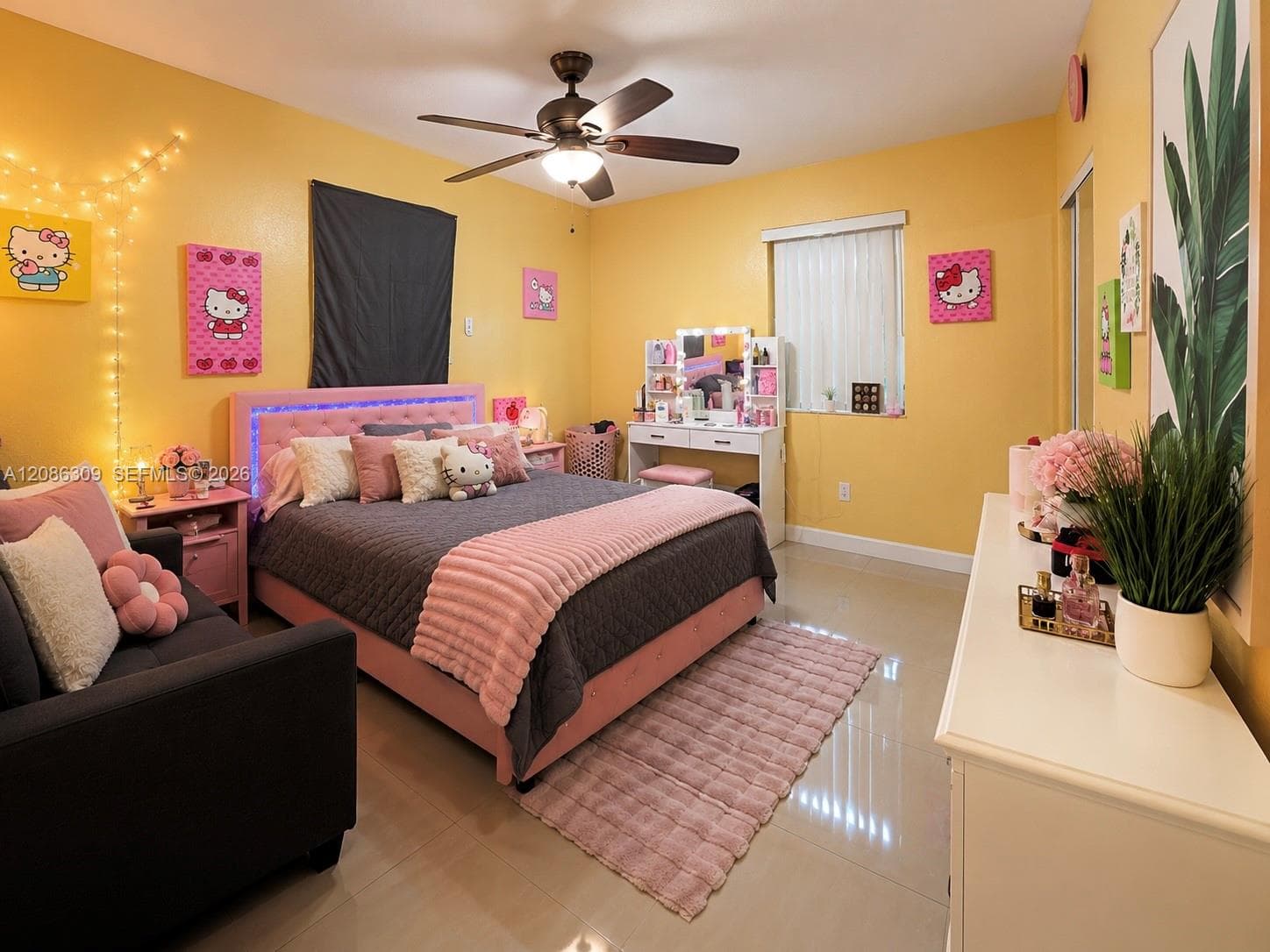Bedroom featuring large-format tile flooring, a central ceiling fan with integrated lighting, and mirrored sliding closet doors