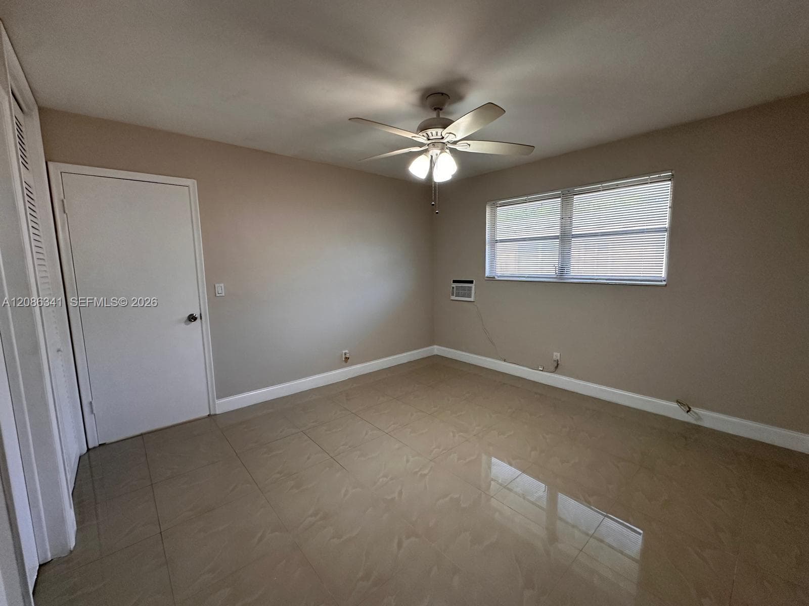 Room featuring tile flooring, ceiling fan with integrated lighting, and louvered closet doors