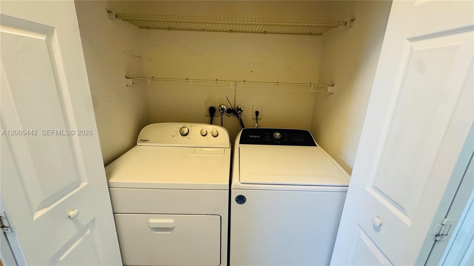 Laundry area featuring dual white top-loading appliances and double-tier wire shelving