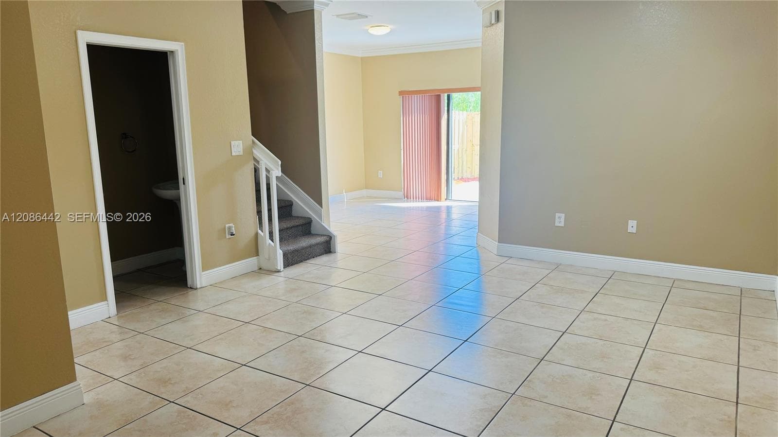 Ceramic tile flooring, staircase with white railing, and sliding glass patio doors