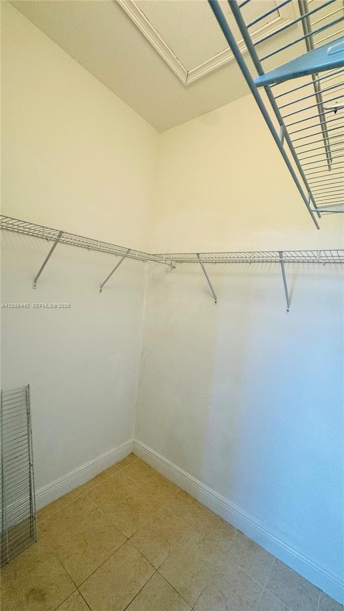 Storage space featuring tiered wire shelving and tiled flooring
