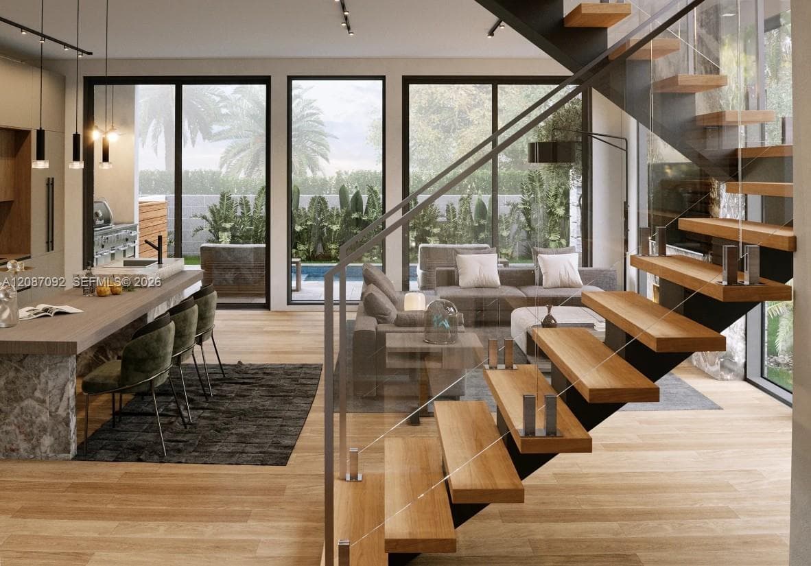Floating staircase with wood treads and glass railing, large-format floor-to-ceiling windows, kitchen island featuring stone-finish base, wood-finish flooring, and minimalist pendant lighting