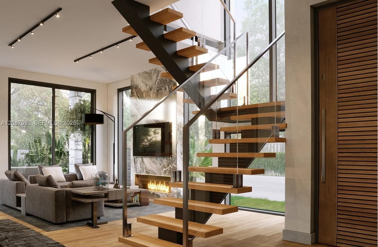 Open-tread staircase featuring wood steps, metal support structure, and glass panel railing, accented by a stone-surround linear fireplace and floor-to-ceiling windows