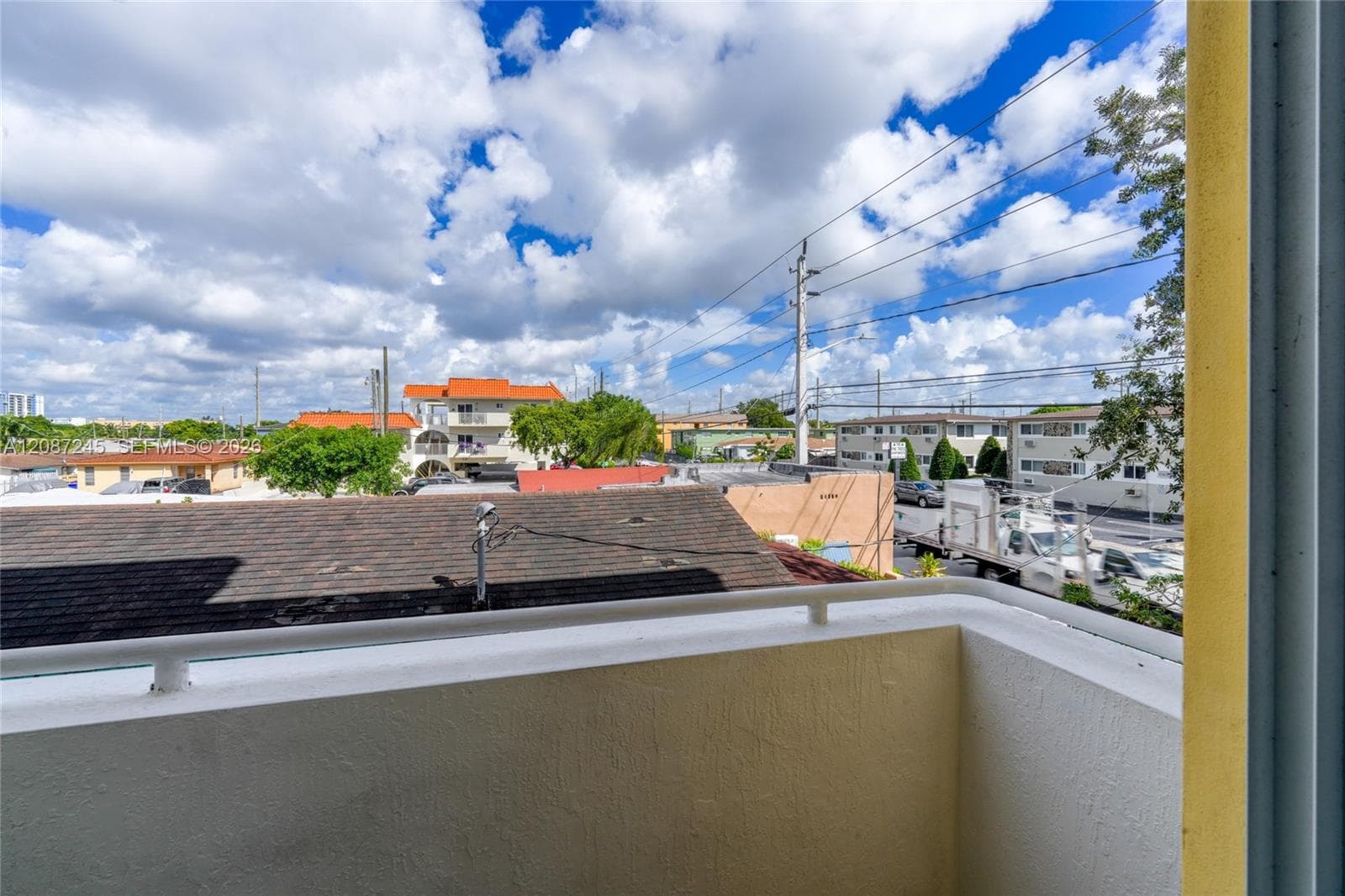 Balcony with a white metal railing and stucco walls