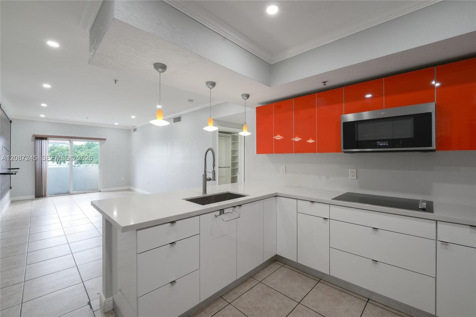 Contemporary kitchen featuring high-gloss orange upper cabinetry, white lower cabinetry, solid-surface countertops, an undermount sink with a gooseneck faucet, and recessed lighting