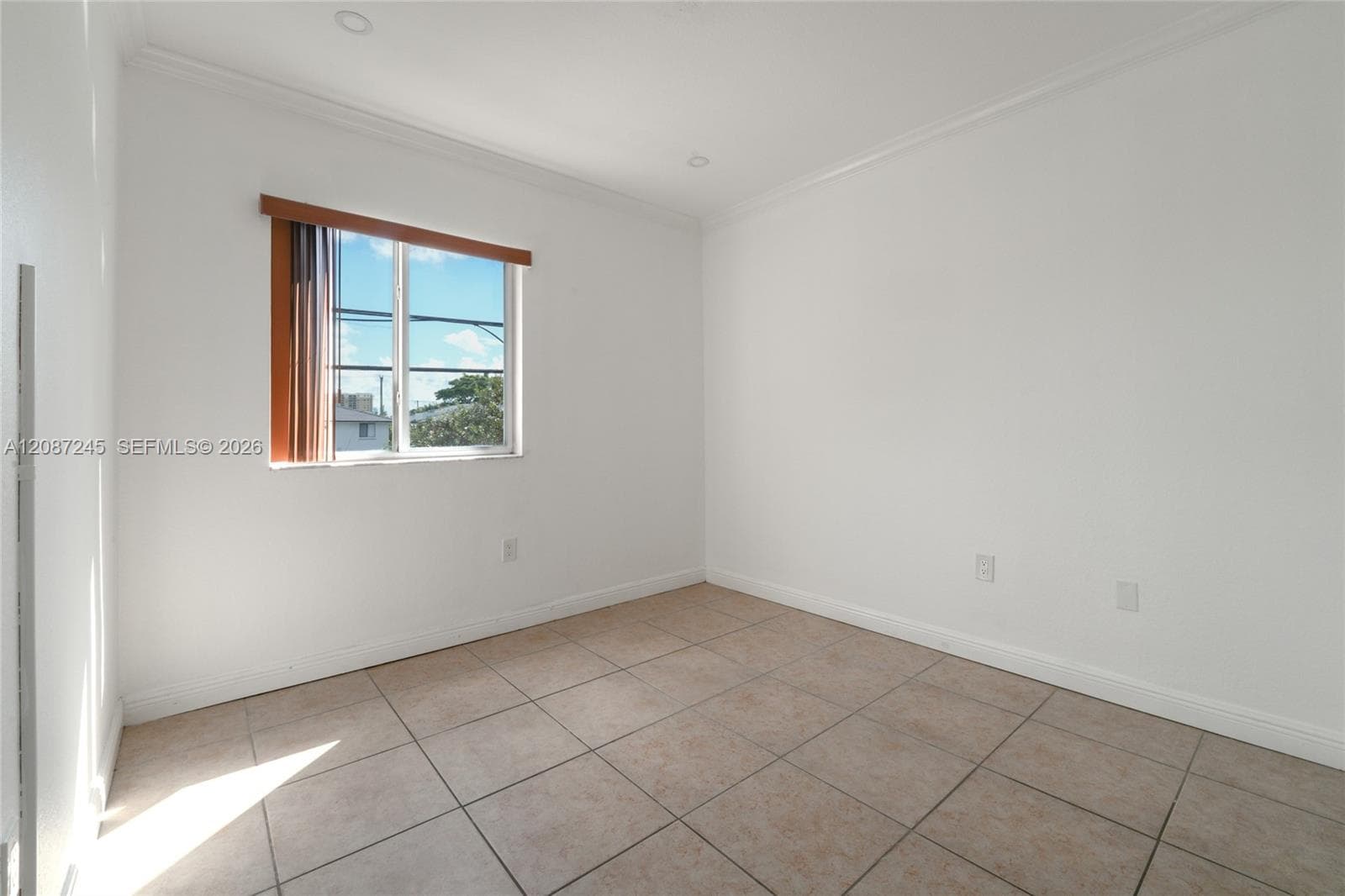 Neutral interior space featuring ceramic tile flooring, crisp white wall finishes, crown molding, and recessed lighting