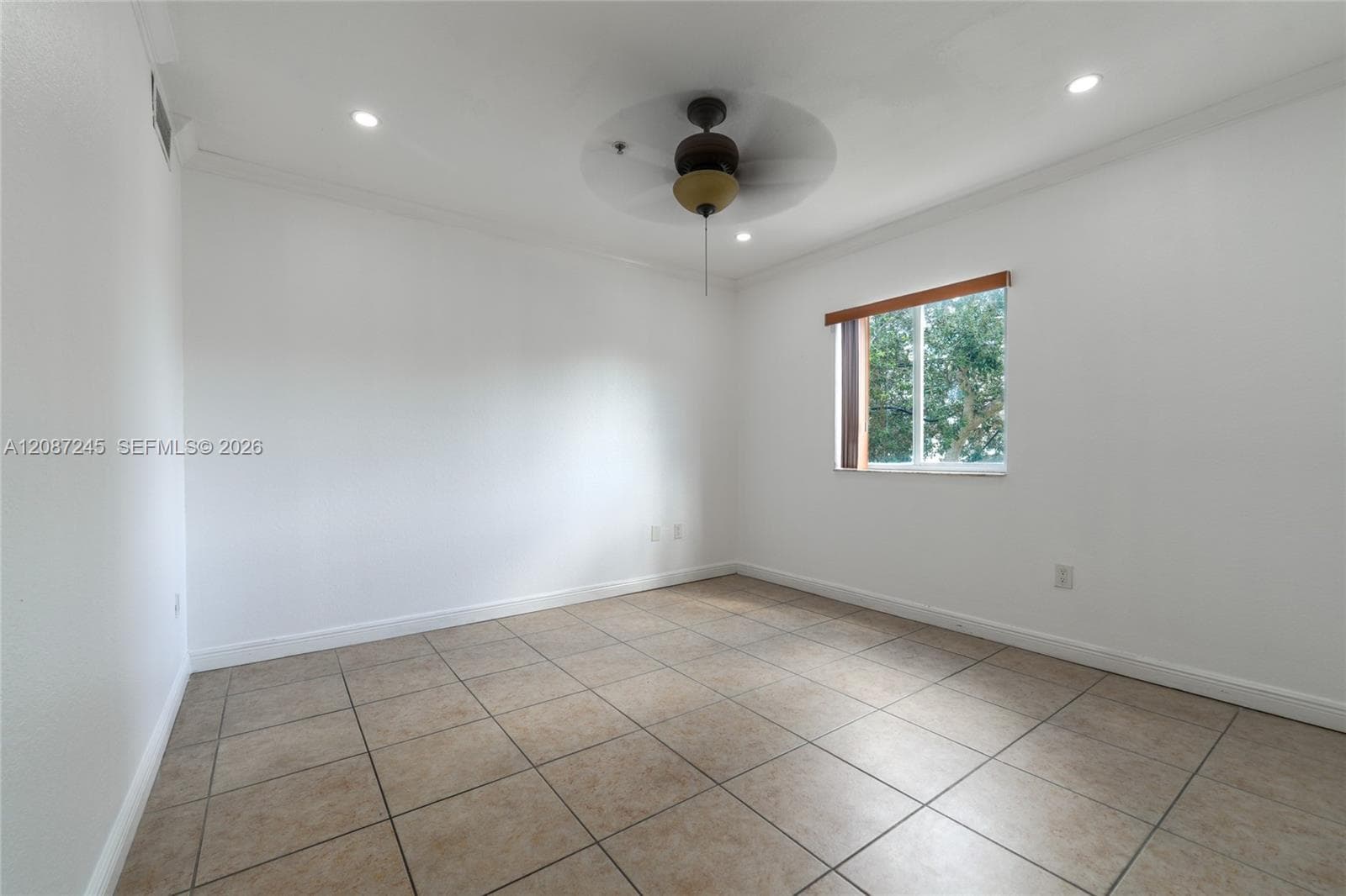 Neutral interior space featuring tile flooring, recessed lighting, a ceiling fan with integrated lighting, and a single-pane window