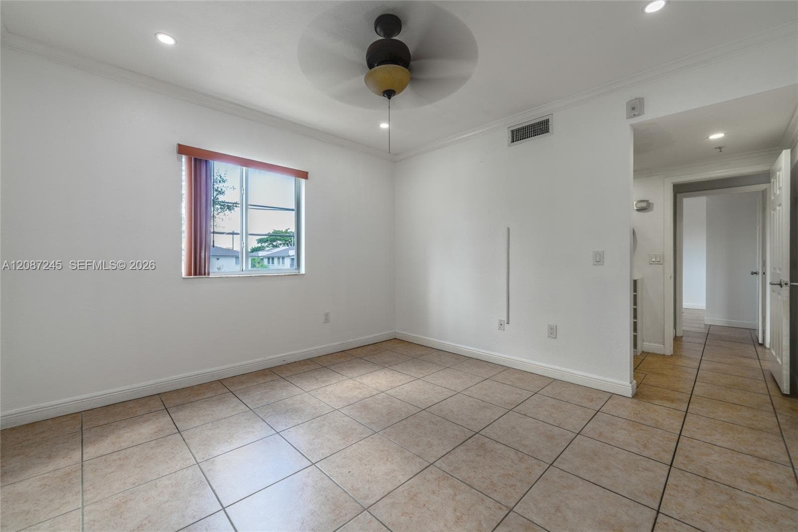 Interior room featuring neutral-toned tile flooring, recessed ceiling lighting, a centrally located ceiling fan with integrated light fixture, and a single-pane window