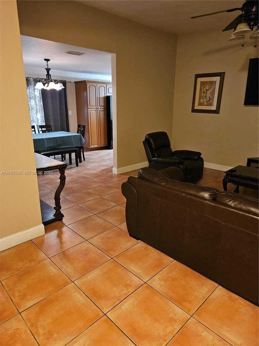 Ceramic tile flooring, ceiling fan with integrated lighting, and built-in wood cabinetry