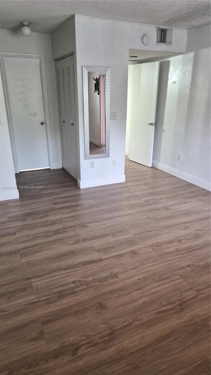 Wood-finish flooring, louvered bi-fold closet doors, and recessed ceiling lighting