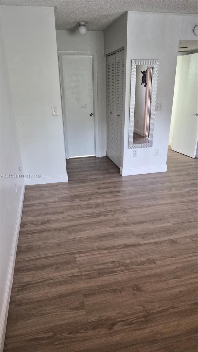 Wood-finish flooring throughout, louvered bi-fold closet doors, and flush-mount ceiling lighting