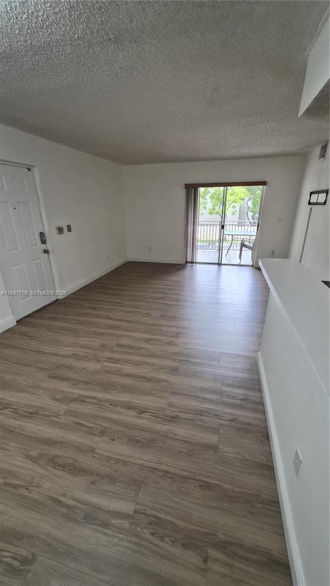 Open-concept interior featuring wood-finish flooring, a glass sliding door, and a built-in counter surface