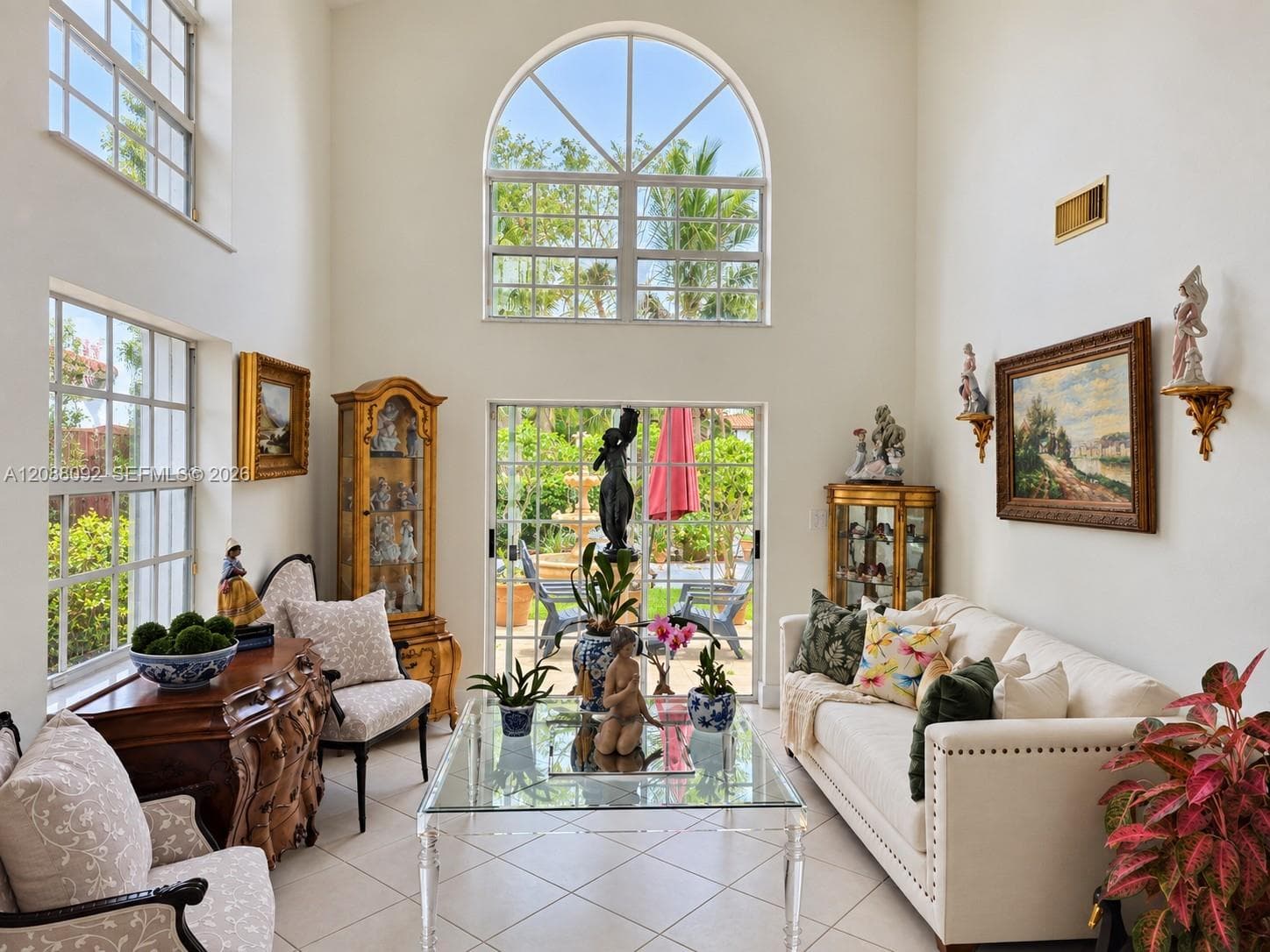 Soaring ceilings and beautiful garden views create a bright, airy living room, with direct access to the lush tropical garden for effortless indoor-outdoor living.