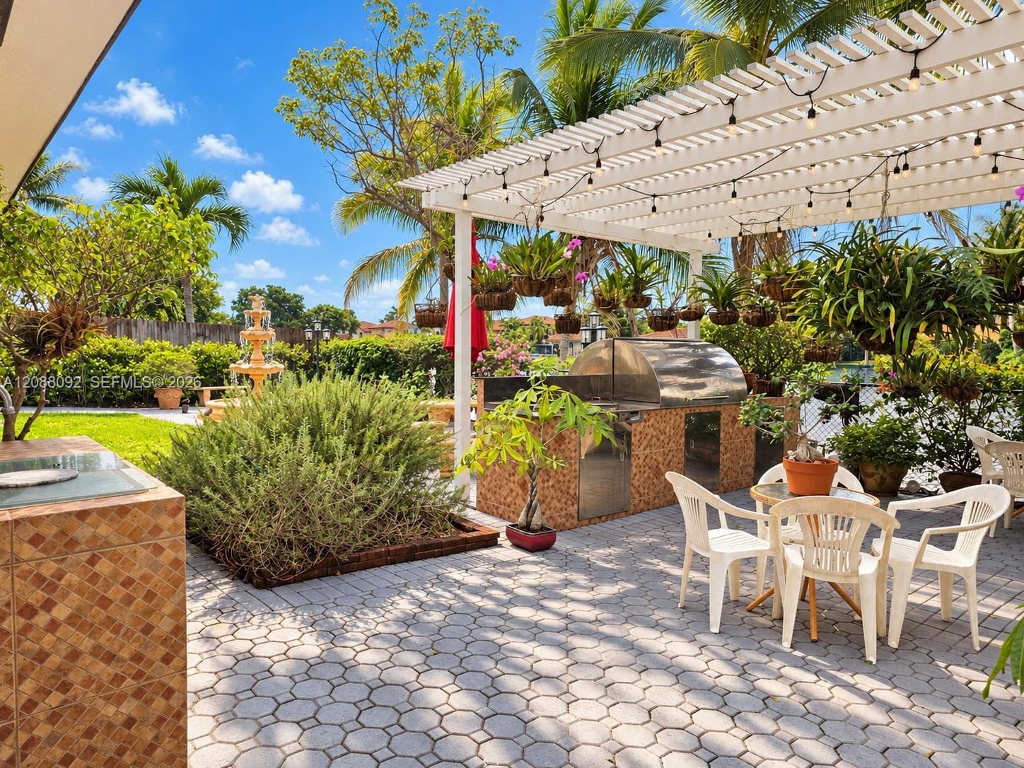 Enjoy morning coffee on the covered patio, unwind beside the water as the sun sets, or gather for dinner prepared in the outdoor kitchen beneath the trellis.