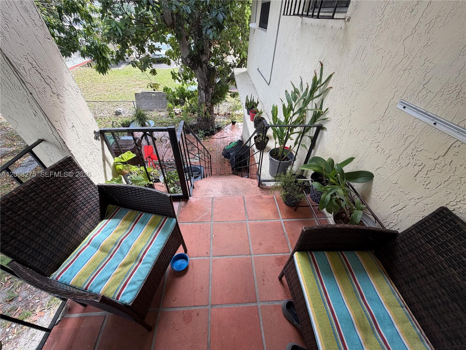Outdoor terrace featuring terracotta-tiled flooring and black wrought-iron railings