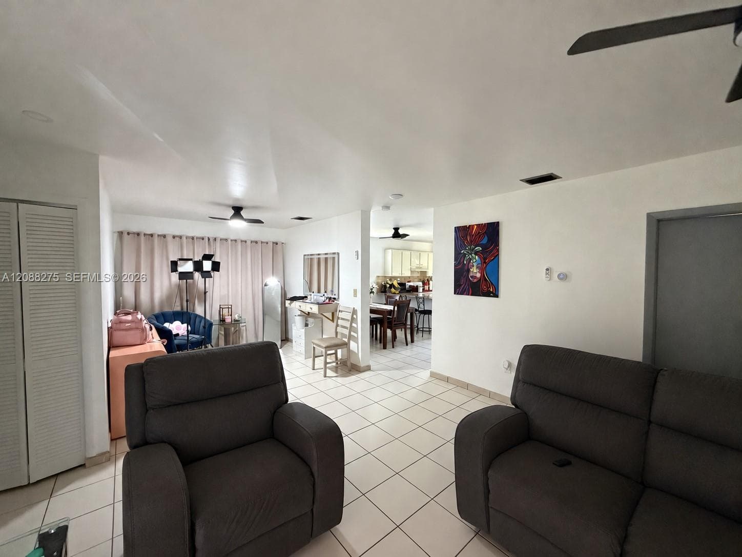 Interior space featuring ceramic tile flooring, neutral wall tones, and dual ceiling fans
