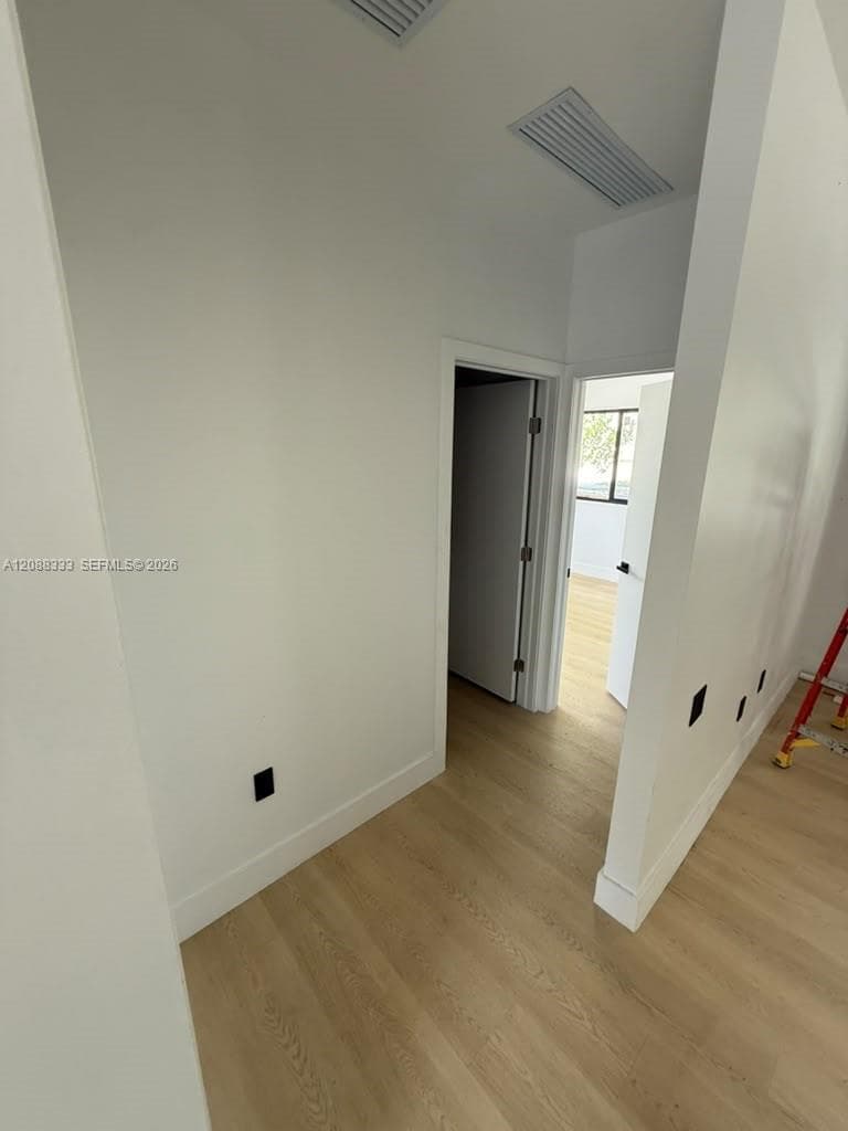 Neutral-toned wall finishes, light wood-finish flooring, and crisp door trim