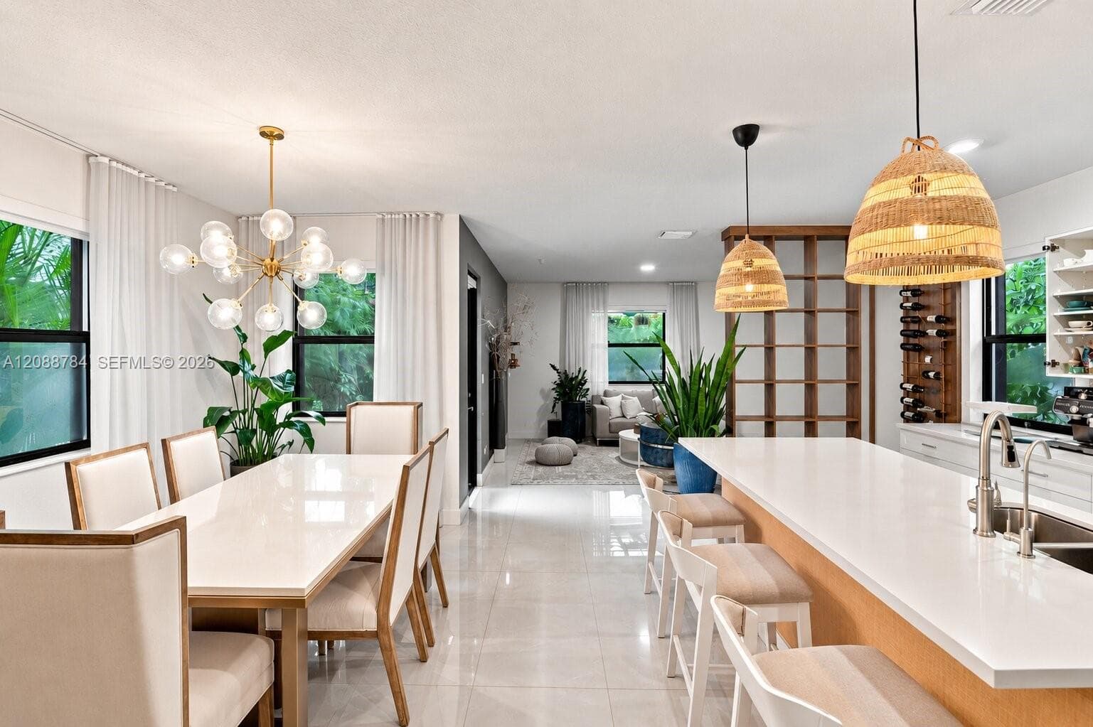 Open-concept interior featuring tile flooring throughout, a kitchen island with seating, built-in shelving, a built-in wine rack, and pendant lighting
