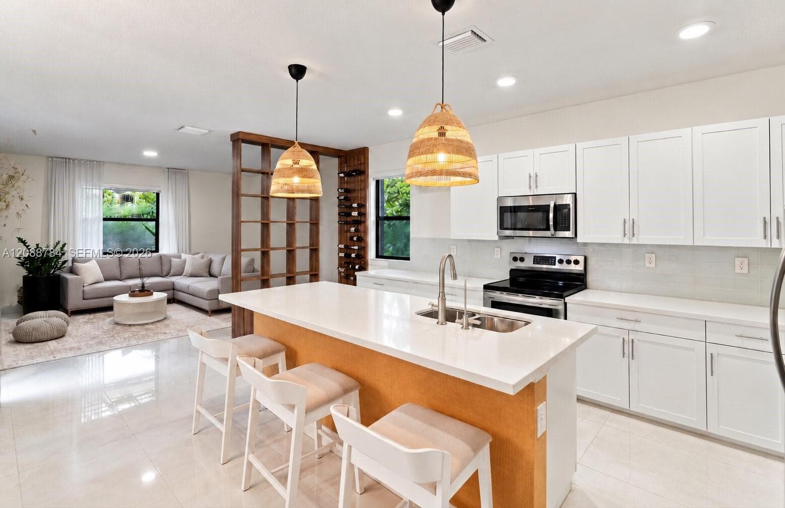 Kitchen featuring white shaker-style cabinetry, white countertops, a stainless steel undermount sink, a built-in wine rack, and tile flooring