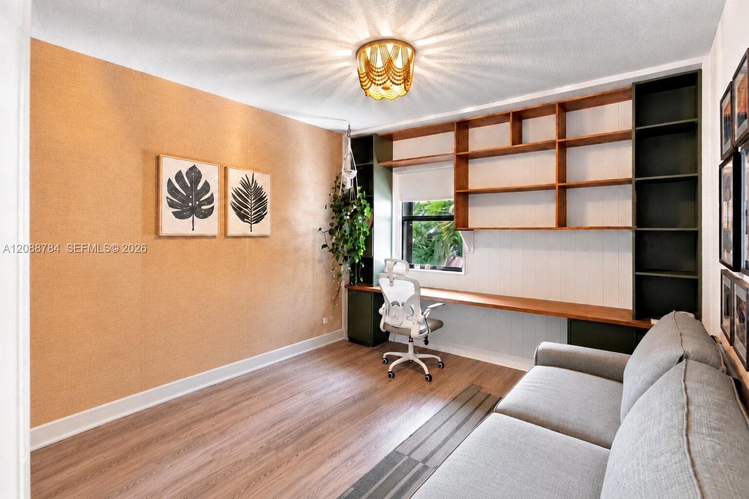 Built-in shelving, wood-finish flooring, recessed window, wall-mounted desk, and ceiling light fixture