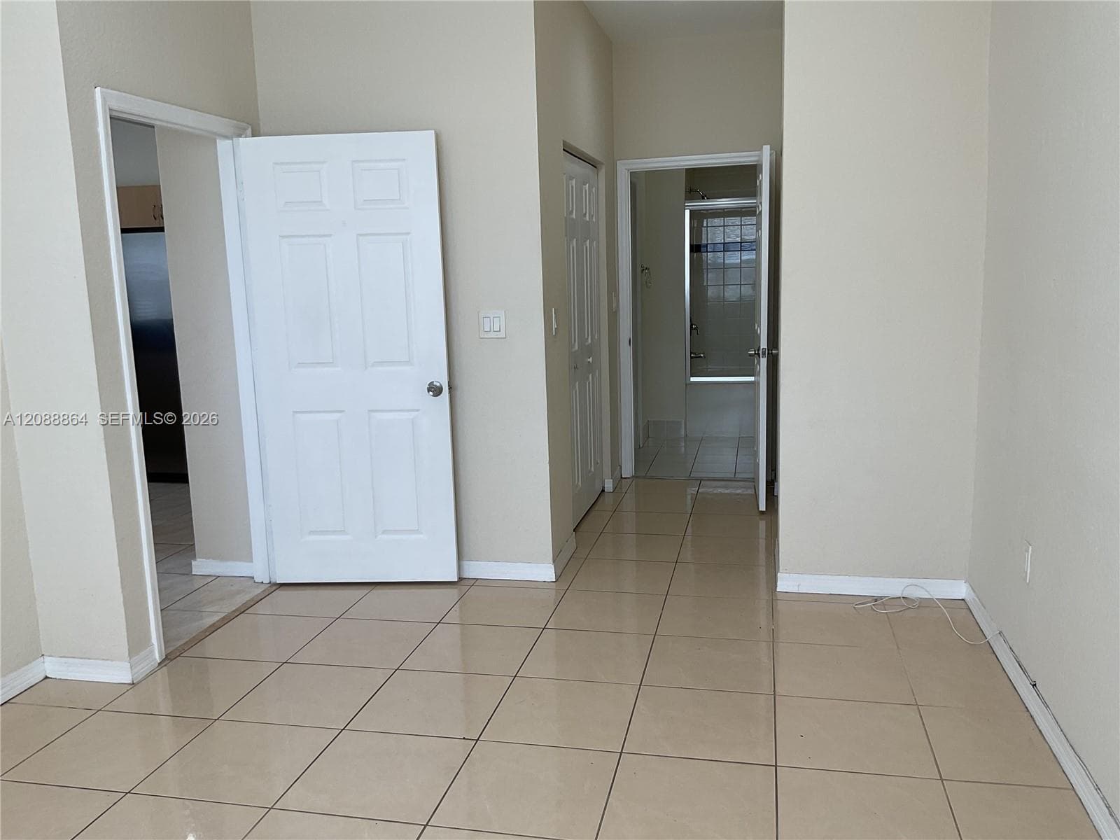 Neutral-toned interior space featuring ceramic tile flooring, solid-core panel doors, and a double-door closet