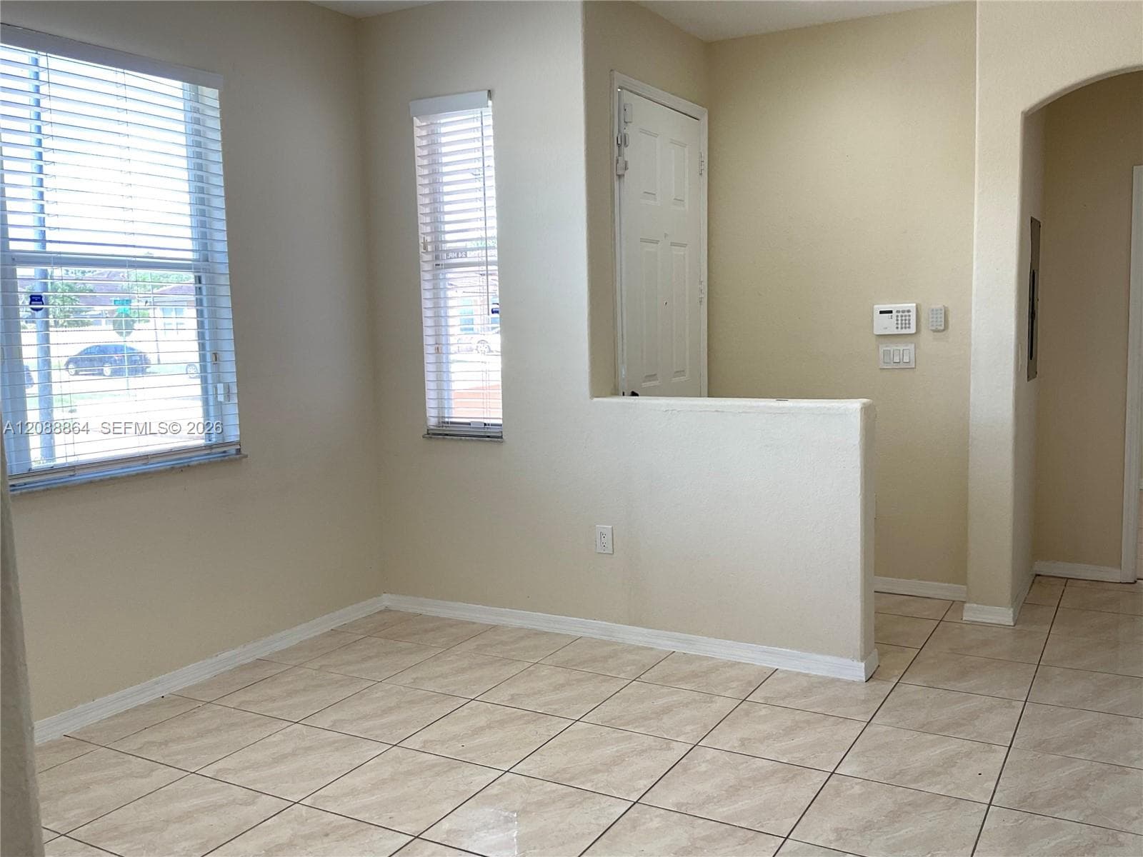 Tile flooring, dual windows with horizontal blinds, and a neutral wall palette