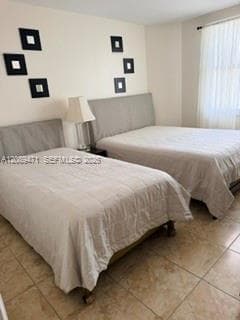 Neutral-toned ceramic tile flooring and floor-to-ceiling sheer window treatments