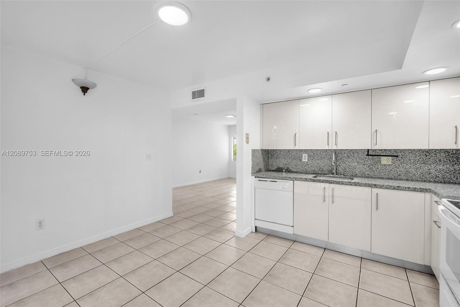 Kitchen featuring high-gloss cabinetry, stone-finish countertops, tile flooring, and built-in appliances