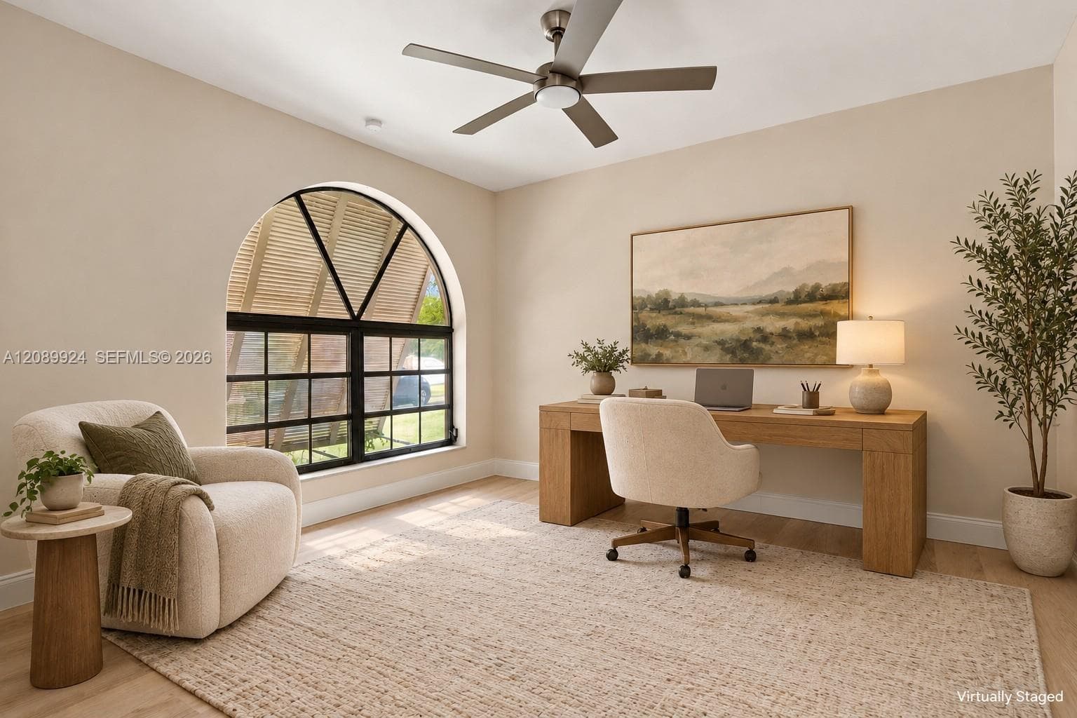 Arched window with black mullions, wood-finish flooring, and a ceiling-mounted light fixture with integrated fan