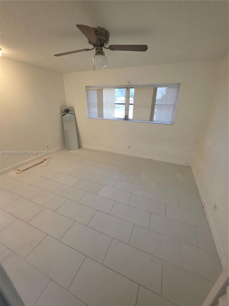 Covered patio featuring wood-finish flooring, dual ceiling fans, and perimeter lattice fencing