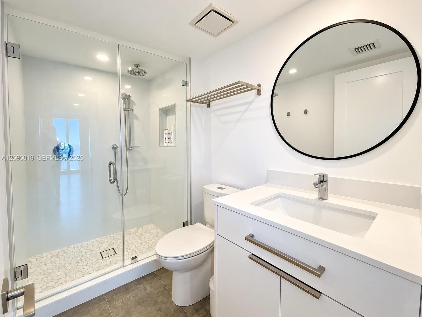 Renovated guest bath with frameless glass shower enclosure.